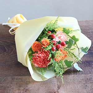 一緒にお届けする花束です。オレンジのカーネーション、黄色やオレンジのスプレーバラに実ものを添えて、秋を感じる色合いに仕立てました。