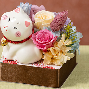 可愛い白猫の周りに、パステルカラーの花々が咲いています。