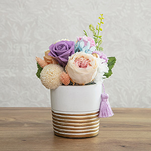 おゴールドラインが特徴的なセメント製の花器に優しい色合いの花々を合わせました。