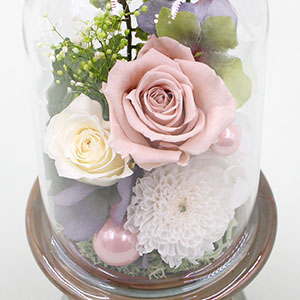 暖かな色合いの花々と淡いピンクのパールピックがあしらわれています。